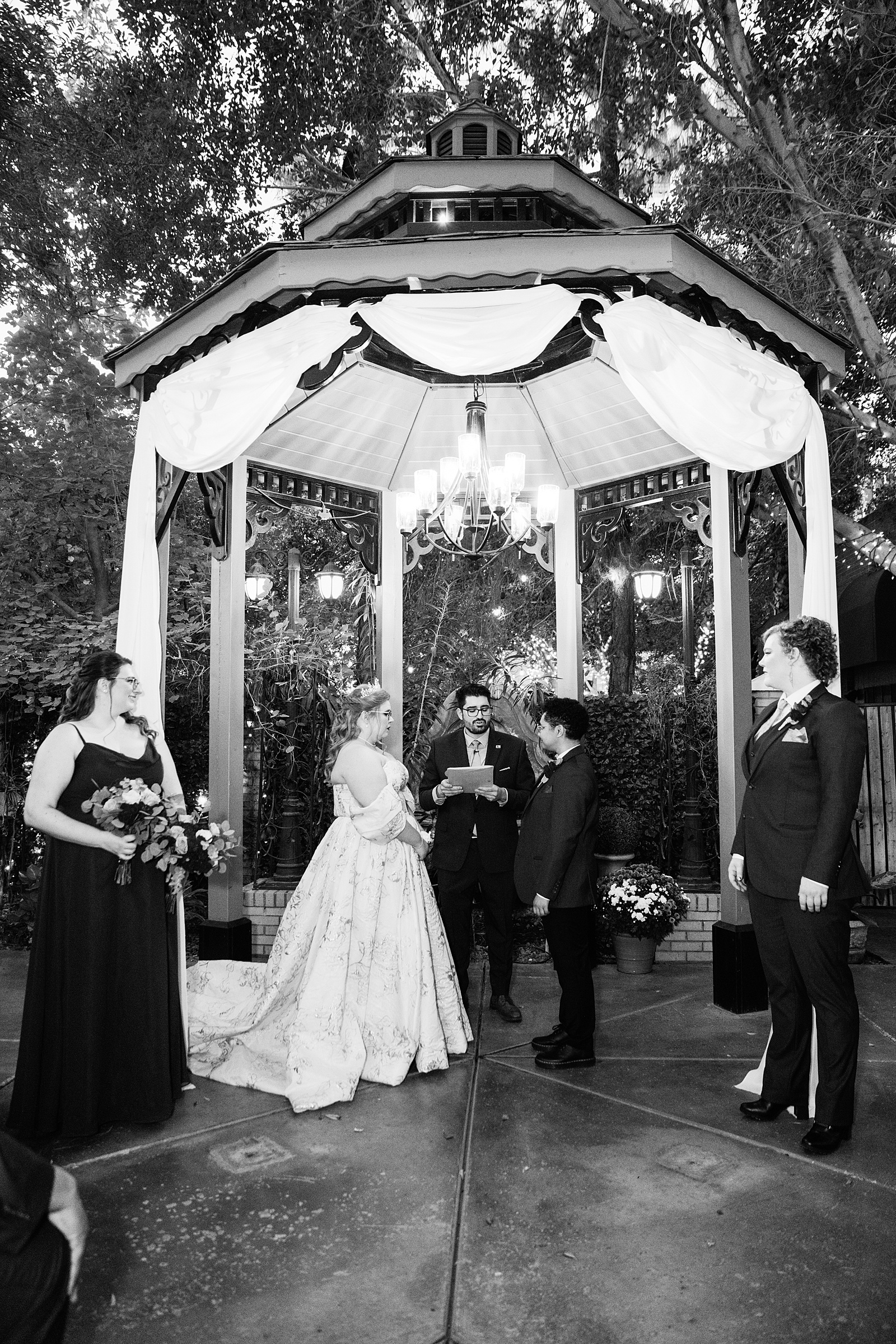 Same sex couple exchange vows during their Regency Garden wedding ceremony by Mesa wedding photographer Juniper and Co Photography.