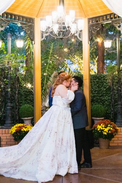 Same sex couple share their first kiss during their wedding ceremony at Regency Garden by Arizona wedding photographer Juniper and Co Photography.