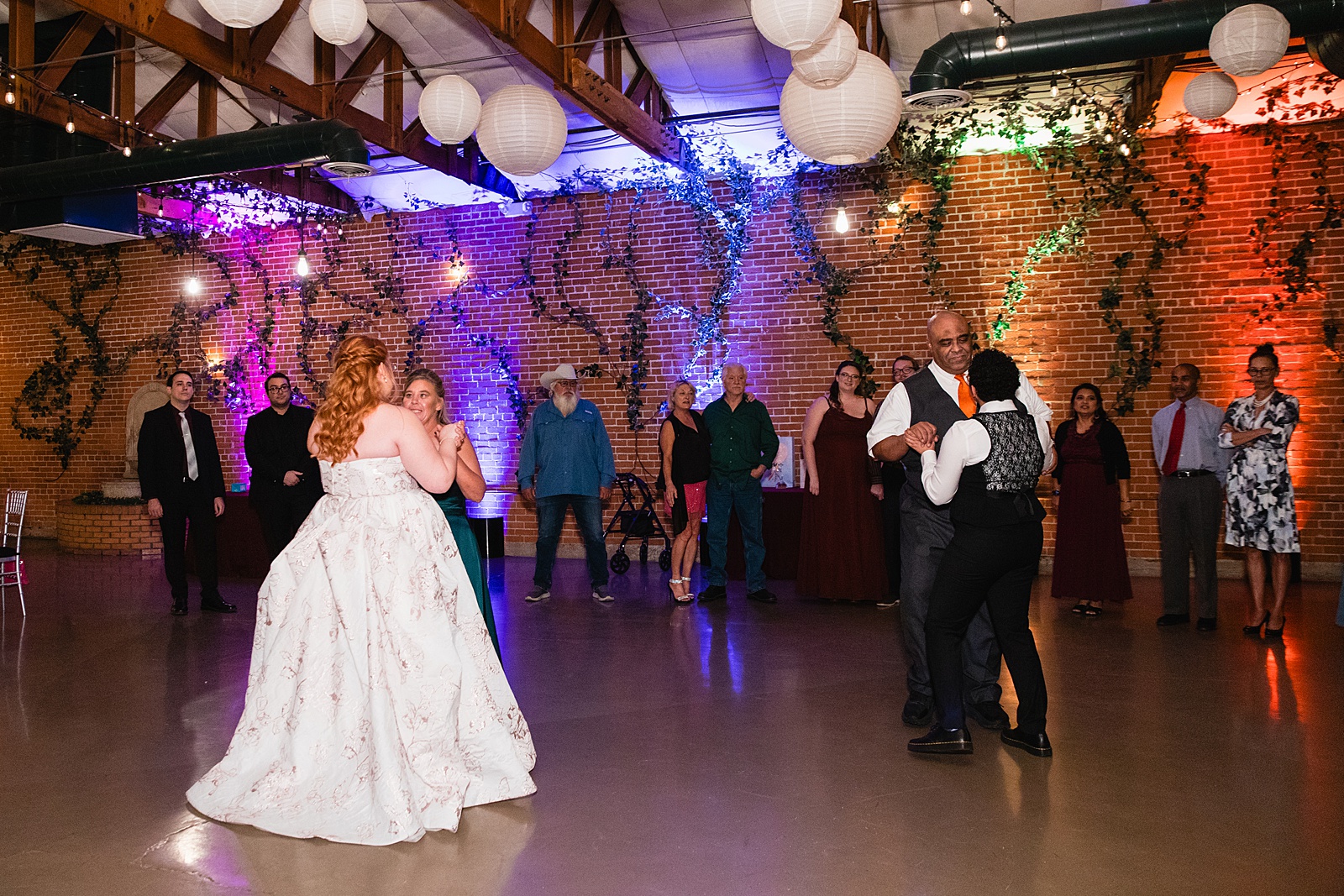 Same sex couple dancing with parents at their Regency Garden wedding reception by Arizona wedding photographer Juniper and Co Photography.