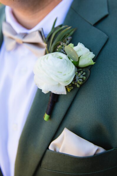 Groom's sage green suit with white boutonniere for his Phoenix desert intimate wedding by Juniper and Co Photography.