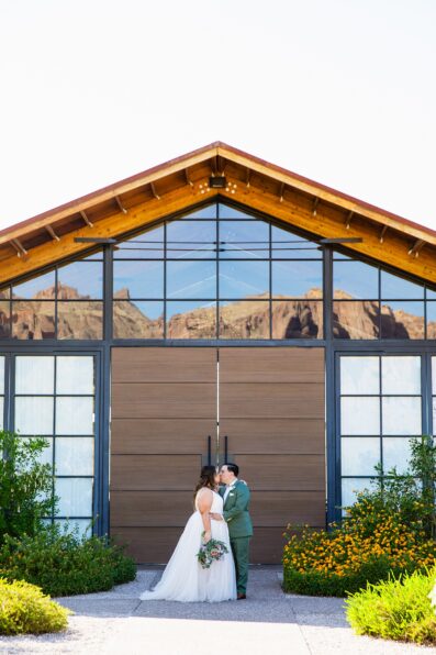 Newlyweds share a kiss during their Phoenix desert intimate wedding by Arizona wedding photographer Juniper and Co Photography.