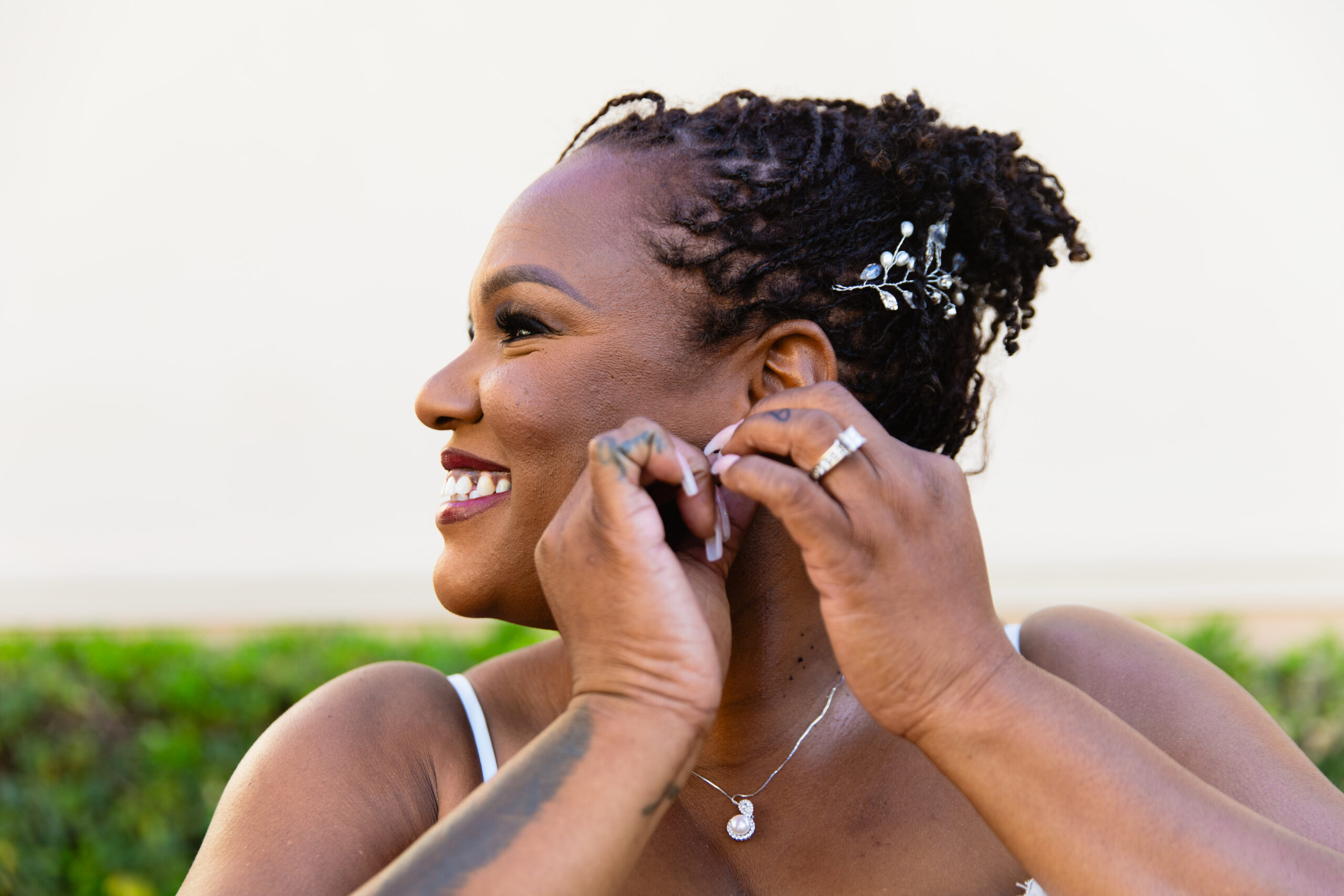 Bride adjusting her earrings on her wedding day by Phoenix wedding photographers Juniper and Co Photography.