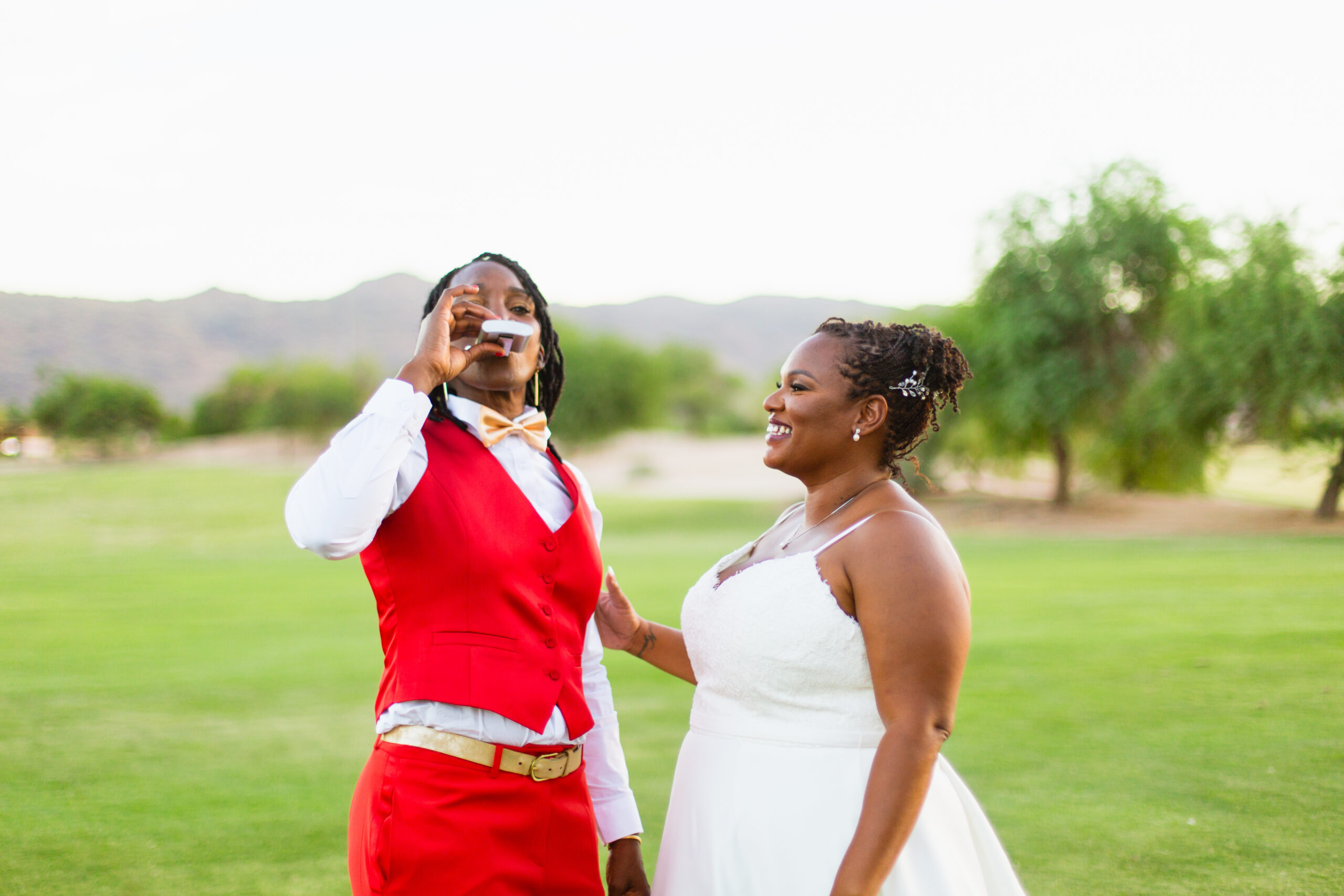 Same sex couple laughing together during their intimate desert wedding by Phoenix wedding photographer Juniper and Co Photography.
