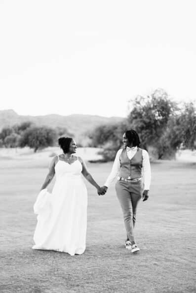 Same sex couple walking together during their intimate desert wedding by Arizona wedding photographer Juniper and Co Photography.