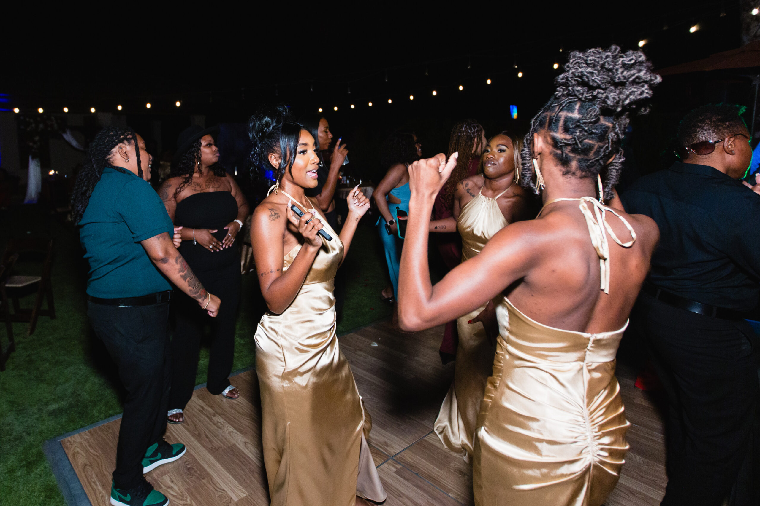 Bridesmaids and guests dancing together at intimate desert wedding reception by Phoenix wedding photographer Juniper and Co Photography