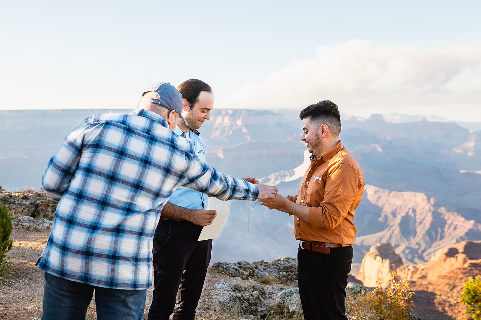 LGBTQ couple exchange rings during their wedding ceremony at Grand Canyon by Arizona elopement photographer Juniper and Co Photography.