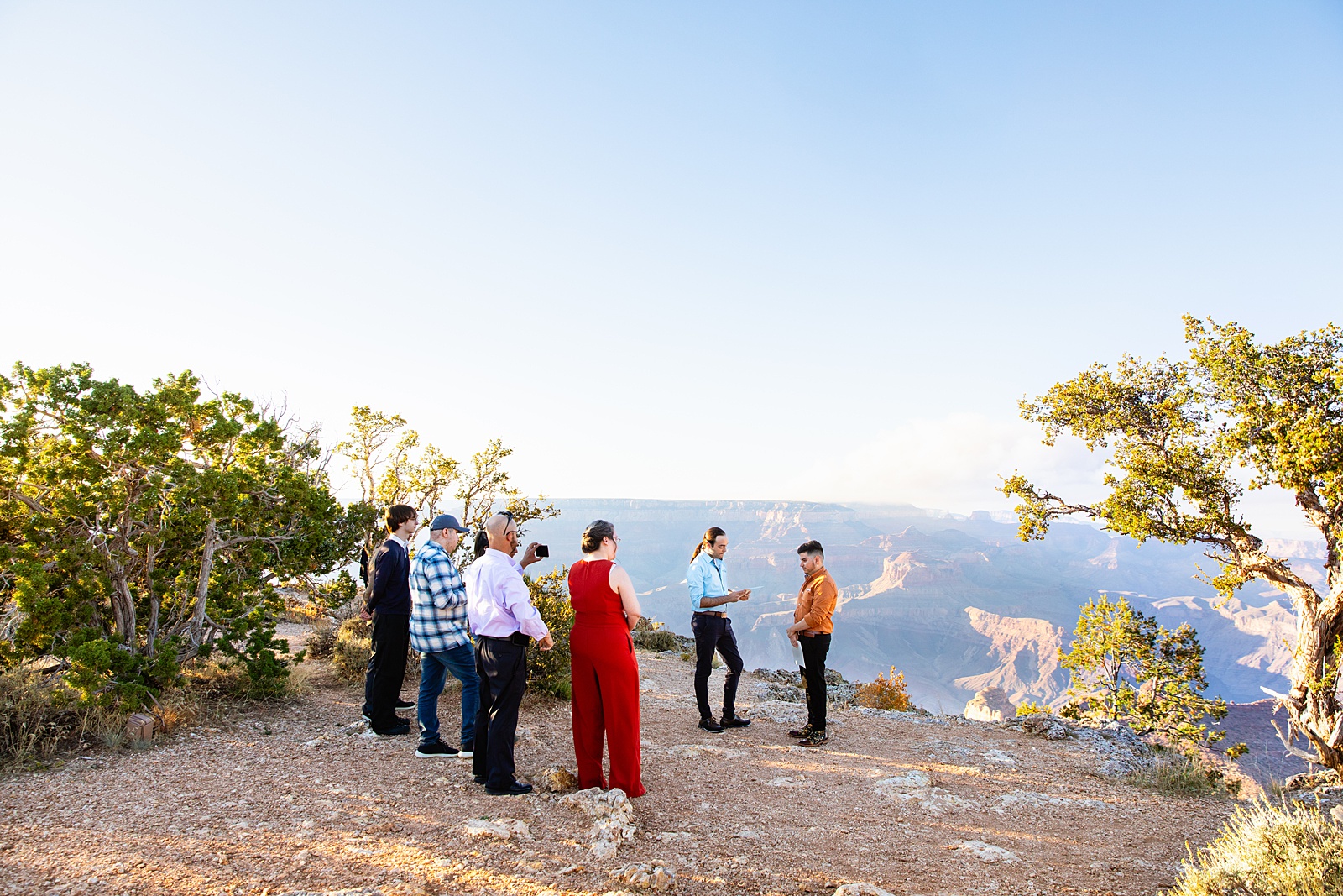 LGBTQ couple exchange rings during their wedding ceremony at Grand Canyon by Arizona elopement photographer Juniper and Co Photography.