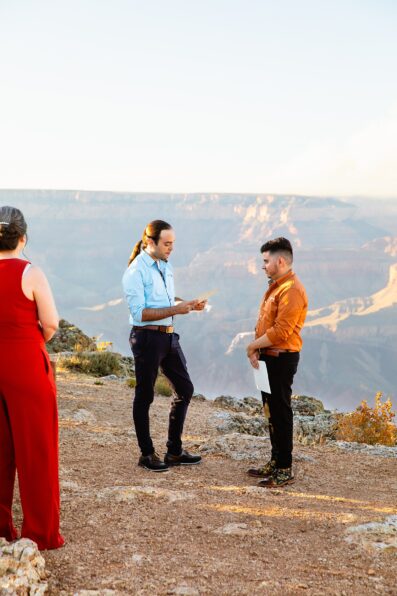 LGBTQ couple exchange vows during their wedding ceremony at Grand Canyon by Arizona elopement photographer Juniper and Co Photography.