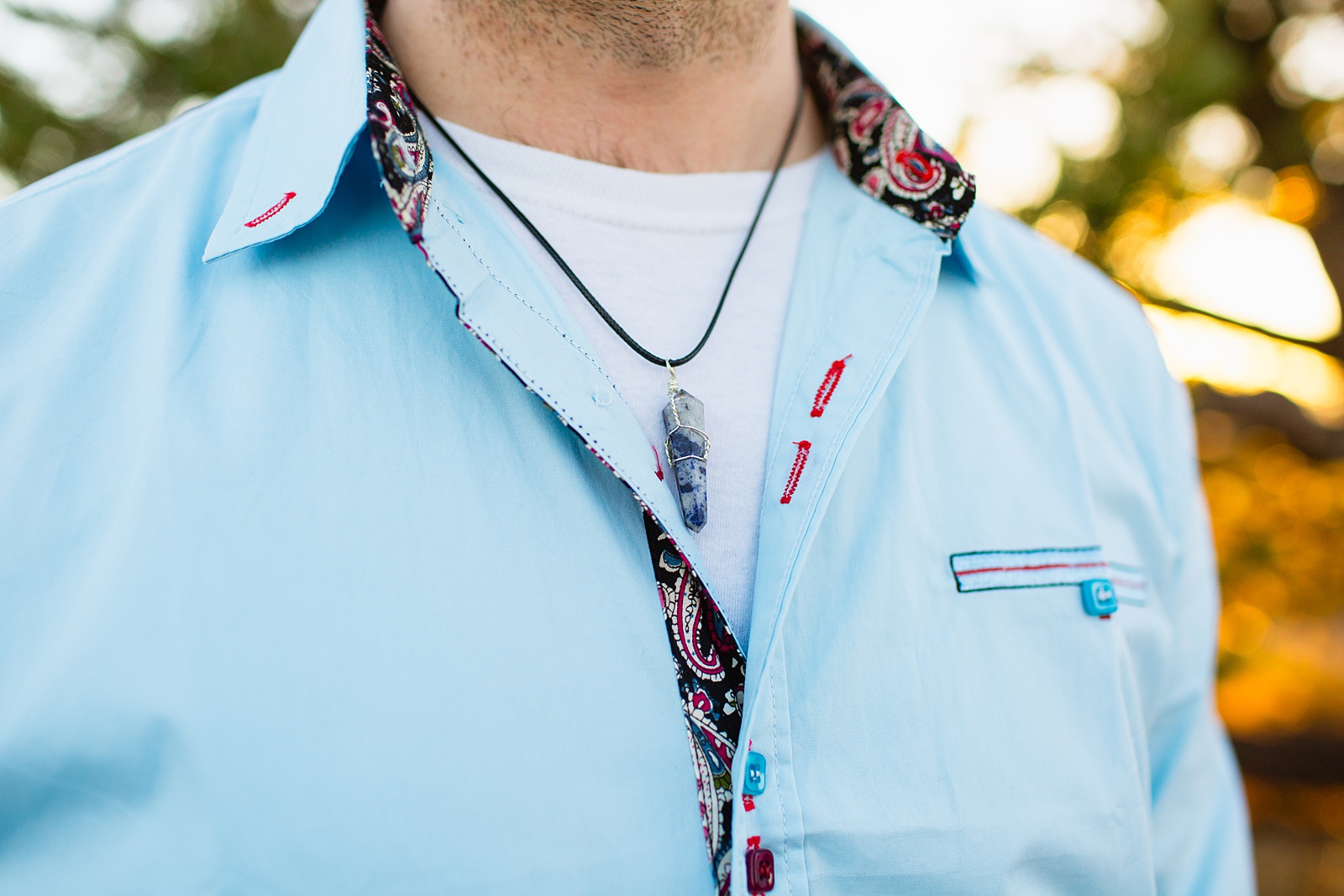 Groom's baby blue colored shirt and stone necklace detail for his Grand Canyon elopement by Juniper and Co Photography.