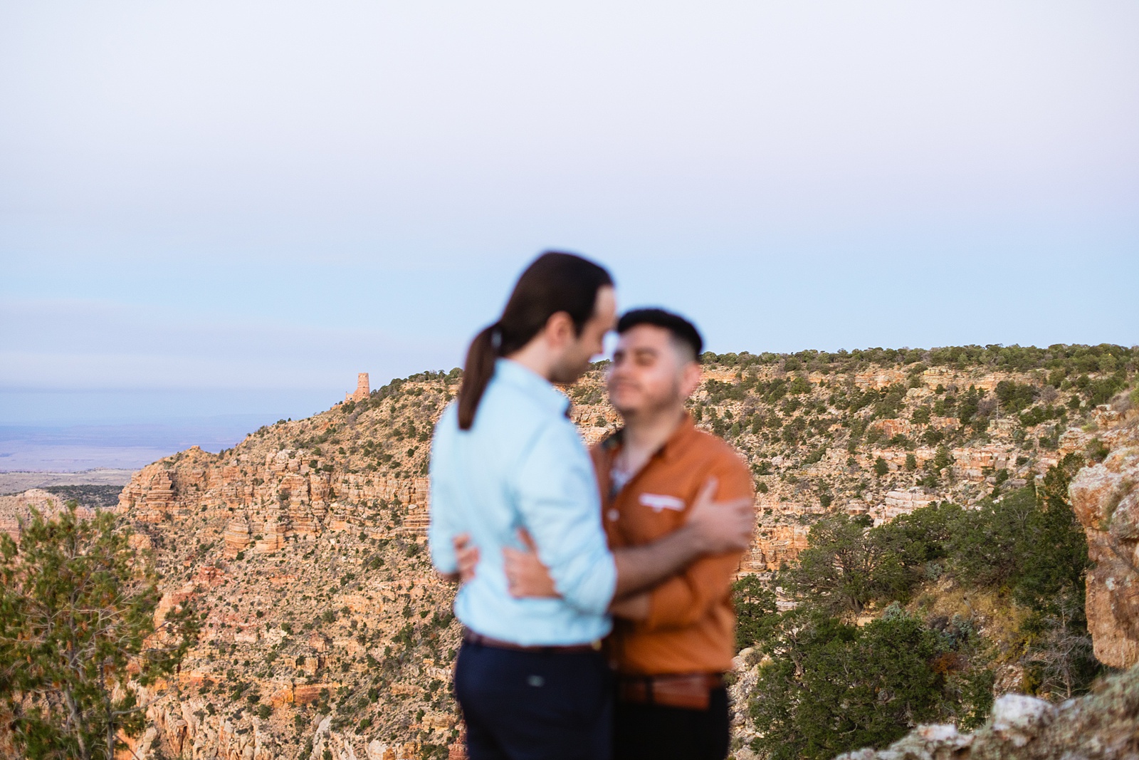 View of the canyon while LGBTQ couple share an intimate moment during their Grand Canyon elopement by Flagstaff elopement photographer Juniper and Co Photography.
