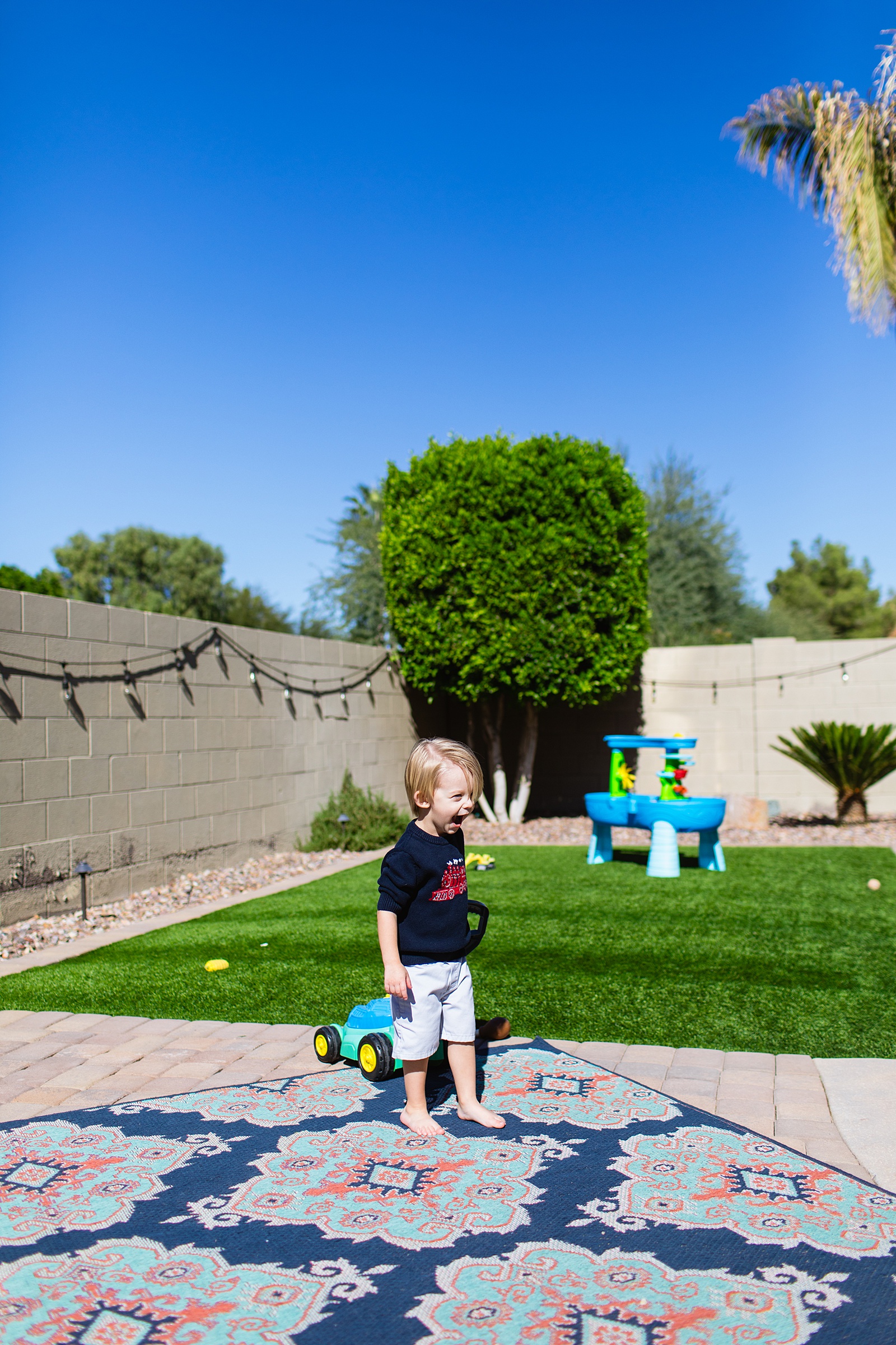 Kid having fun outside for their In Home Newborn family session by Phoenix family photographer Juniper and Co Photography.