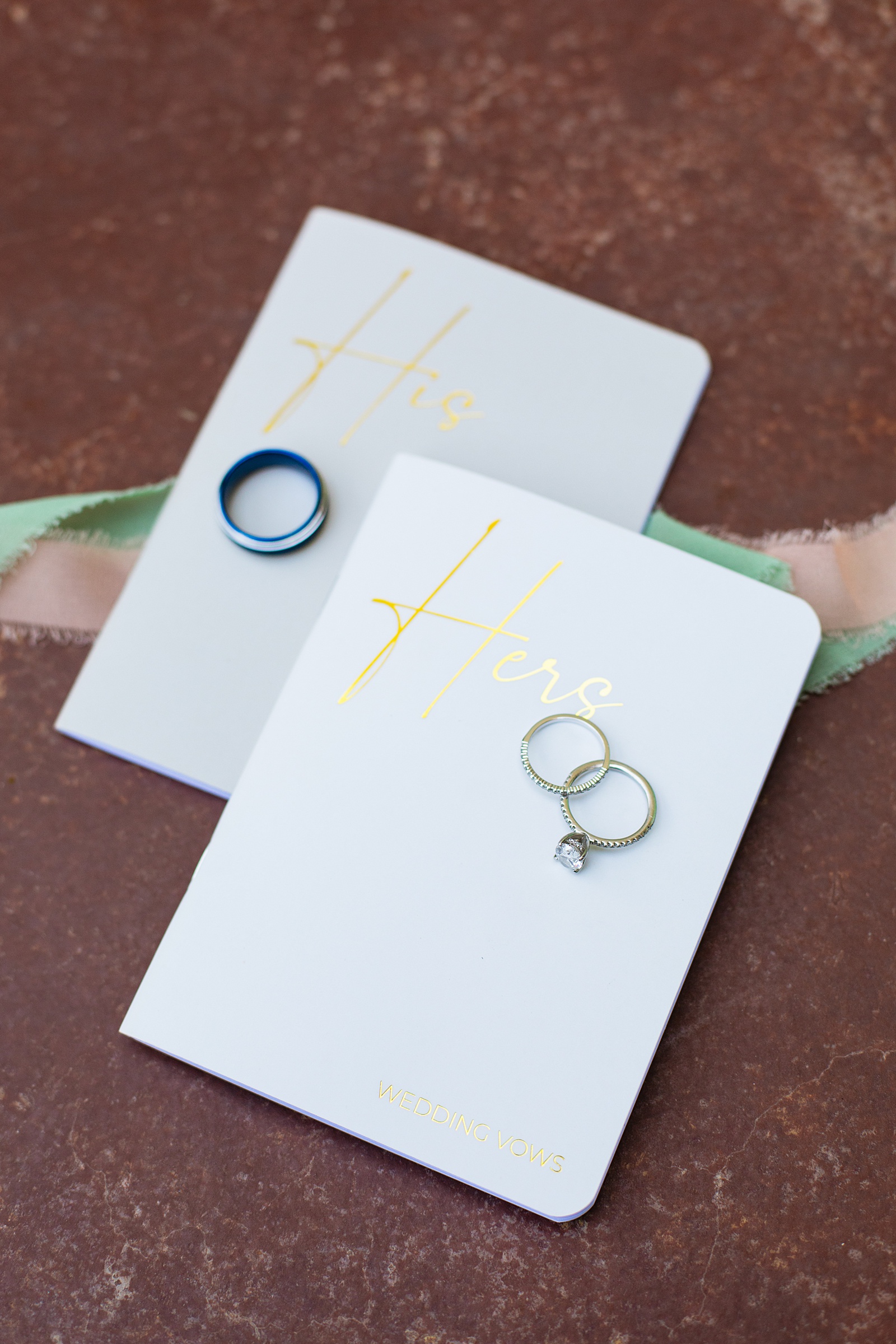 Bride's wedding day details of vow books and wedding bands by Juniper and Co Photography.