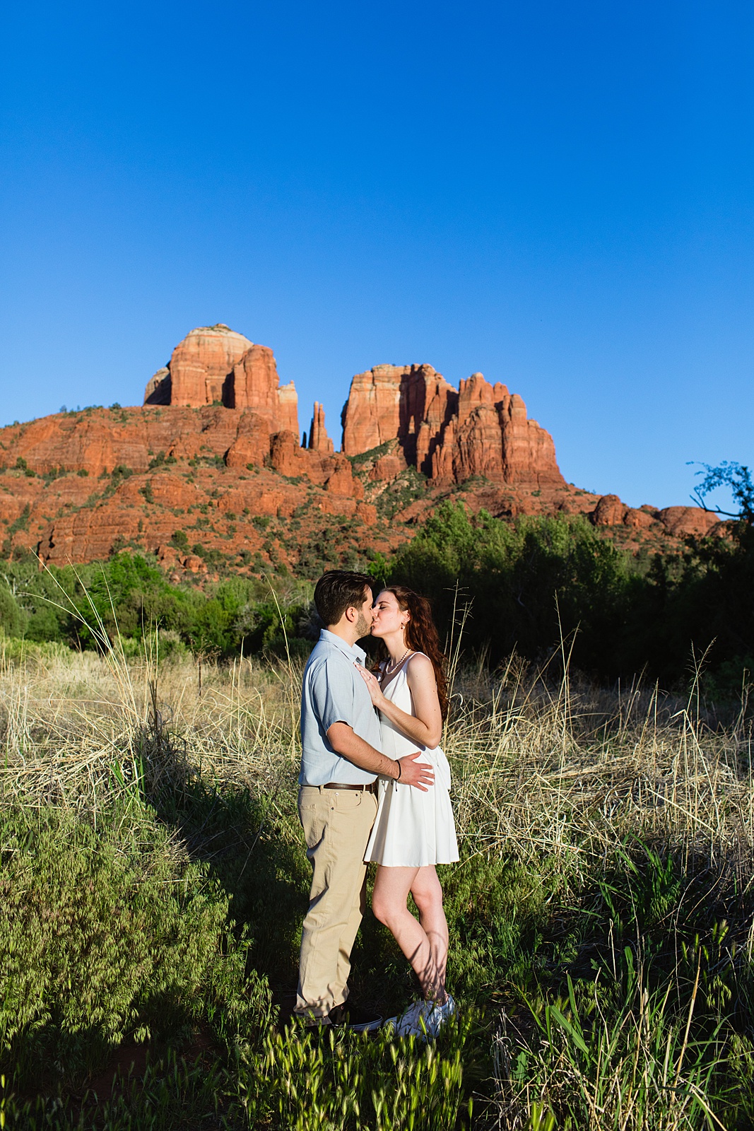 A couple share a kiss during their Sedona engagement session by Arizona wedding photographer Juniper and Co Photography.